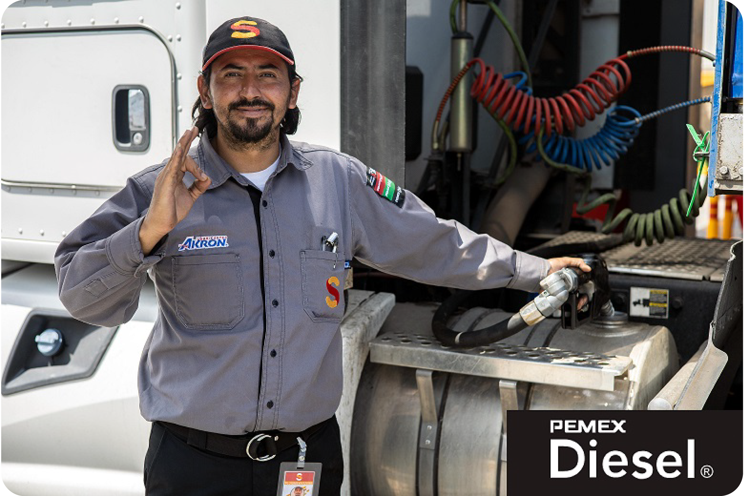Despachador sonriendo con un camión de carga al fondo